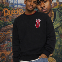 Two men standing in front of a colorful NAS Queens mural