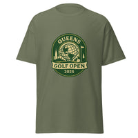 Military Green unisex T-shirt featuring a vintage-style graphic for the "Queens Golf Open 2025." The design includes the Unisphere at the center, surrounded by silhouettes of iconic NYC buildings, a golf ball, and a flagstick. The text "QUEENS GOLF OPEN 2025" is prominently displayed in cream and green tones within a badge-like emblem.