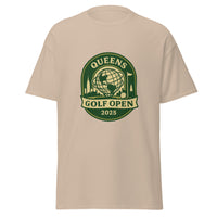 Sand Color unisex T-shirt featuring a vintage-style graphic for the "Queens Golf Open 2025." The design includes the Unisphere at the center, surrounded by silhouettes of iconic NYC buildings, a golf ball, and a flagstick. The text "QUEENS GOLF OPEN 2025" is prominently displayed in cream and green tones within a badge-like emblem.