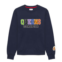 A navy blue sweatshirt with the text 'QUEENS' written across the front in multicolored letters, accompanied by a small 'Borough of NYC' text in red below it. There is also a chenille patch on the upper left side of the sweatshirt.