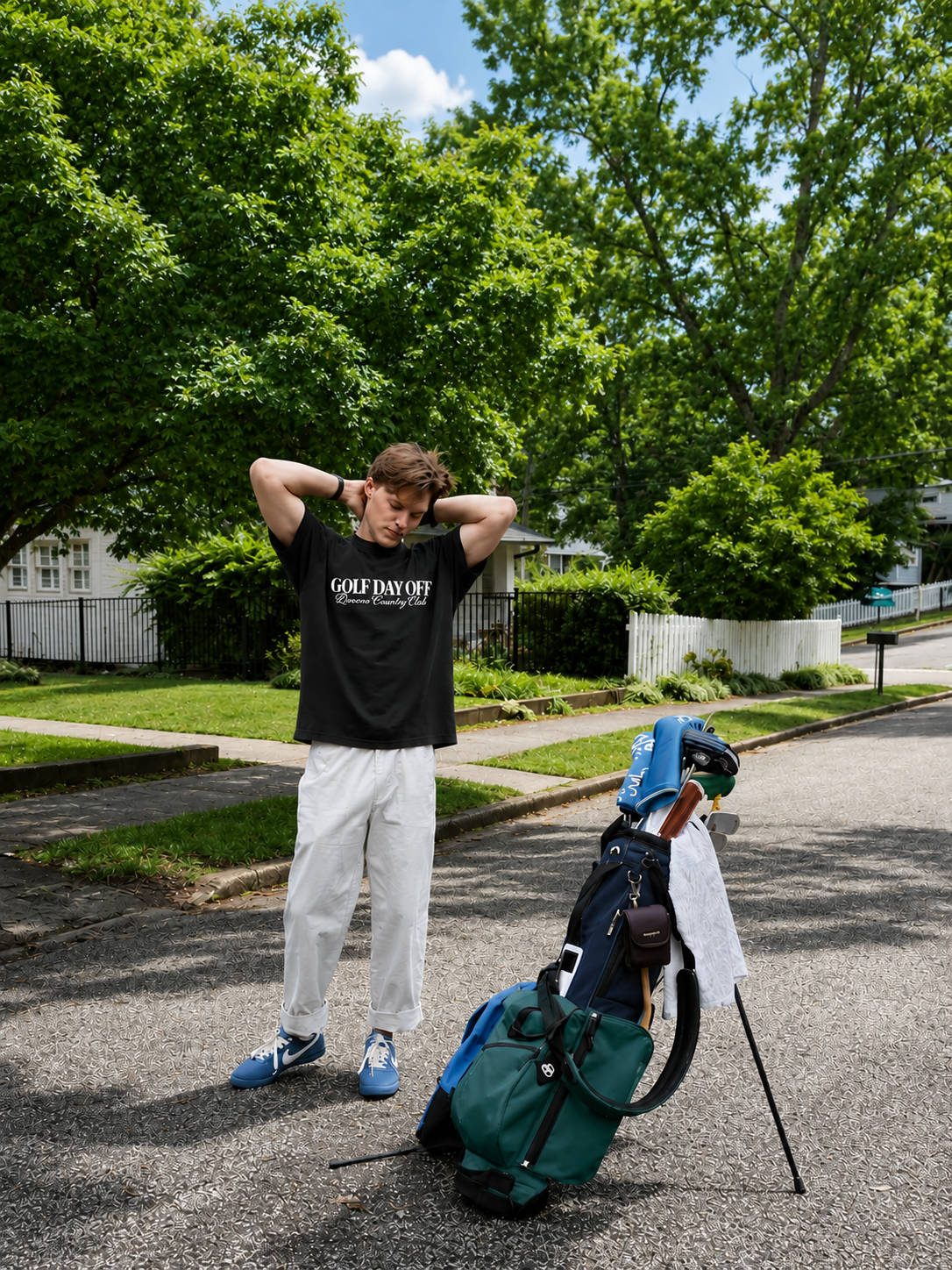 Person stretching with a golf bag and clubs on a residential street