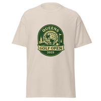 Natural Color unisex T-shirt featuring a vintage-style graphic for the "Queens Golf Open 2025." The design includes the Unisphere at the center, surrounded by silhouettes of iconic NYC buildings, a golf ball, and a flagstick. The text "QUEENS GOLF OPEN 2025" is prominently displayed in cream and green tones within a badge-like emblem.