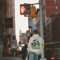 Person walking on a city street with traffic lights and buildings in the background
