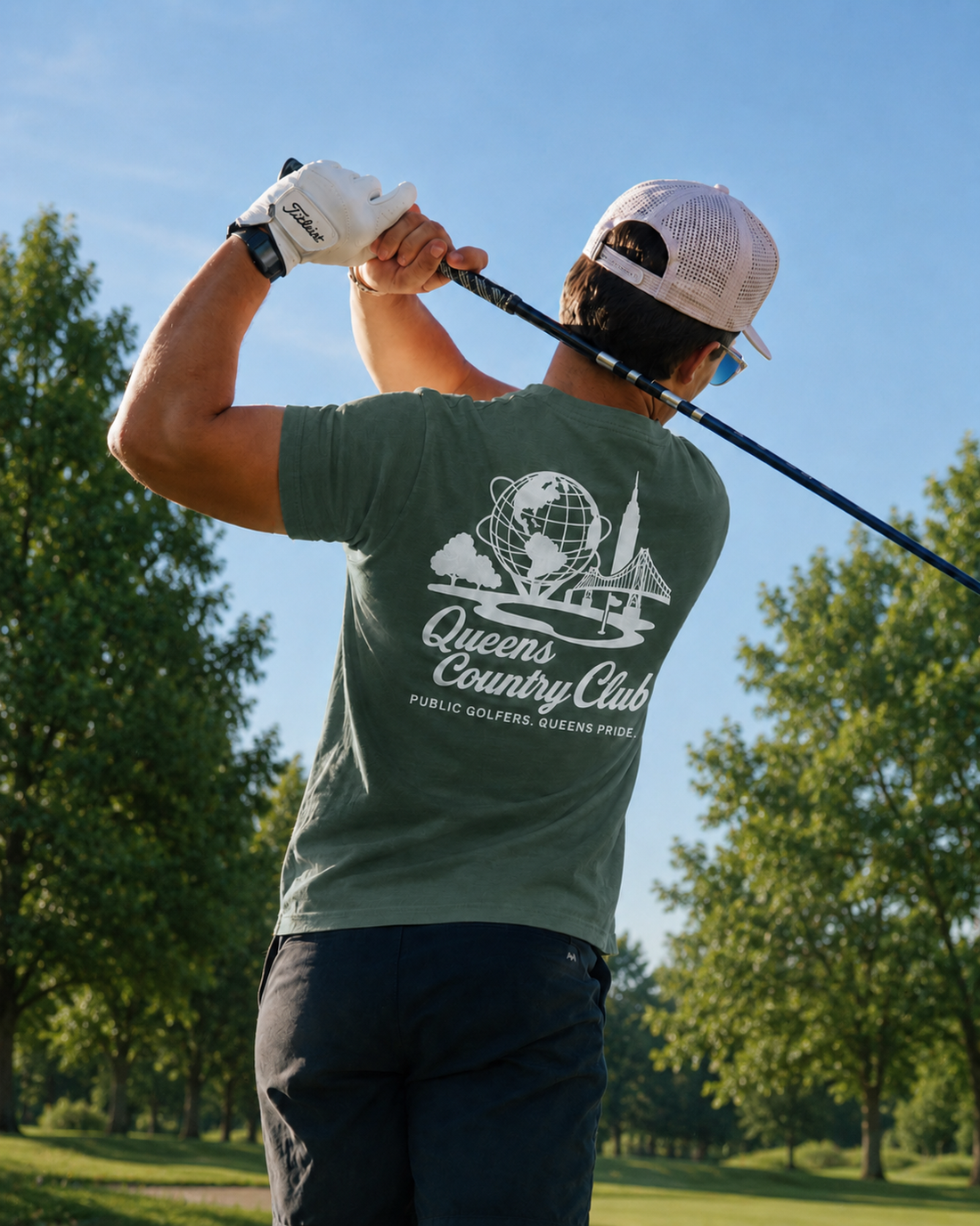 Man golfing on a course with 'Queens Country Club' t-shirt