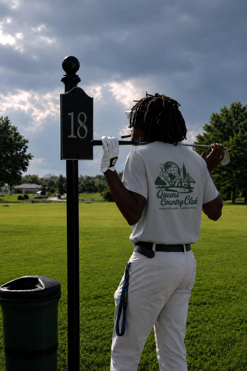 Person holding a golf club with a '18' marker on a golf course